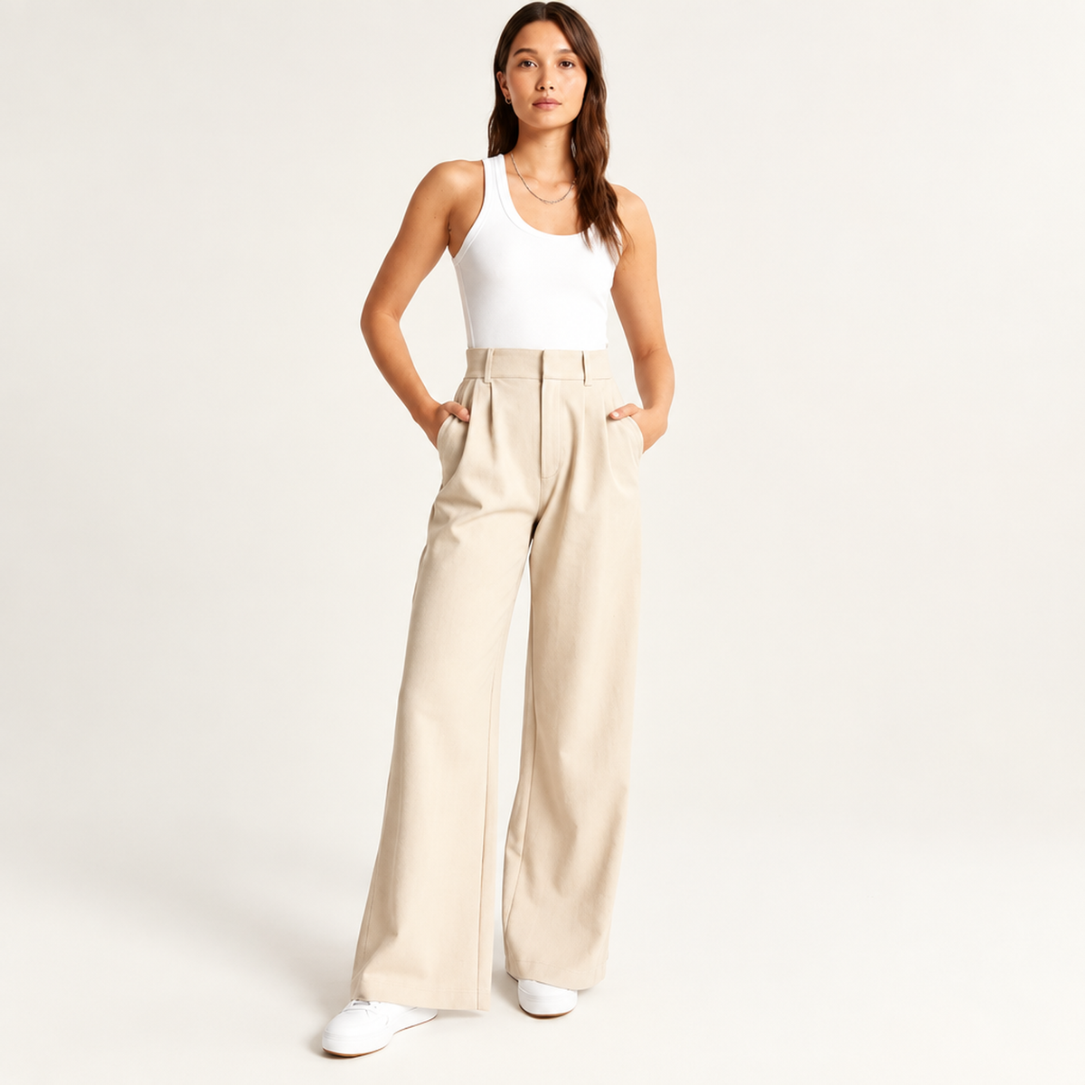 Pantalon large taille haute femme en beige, vue de face avec plis pincés et poches passepoilées