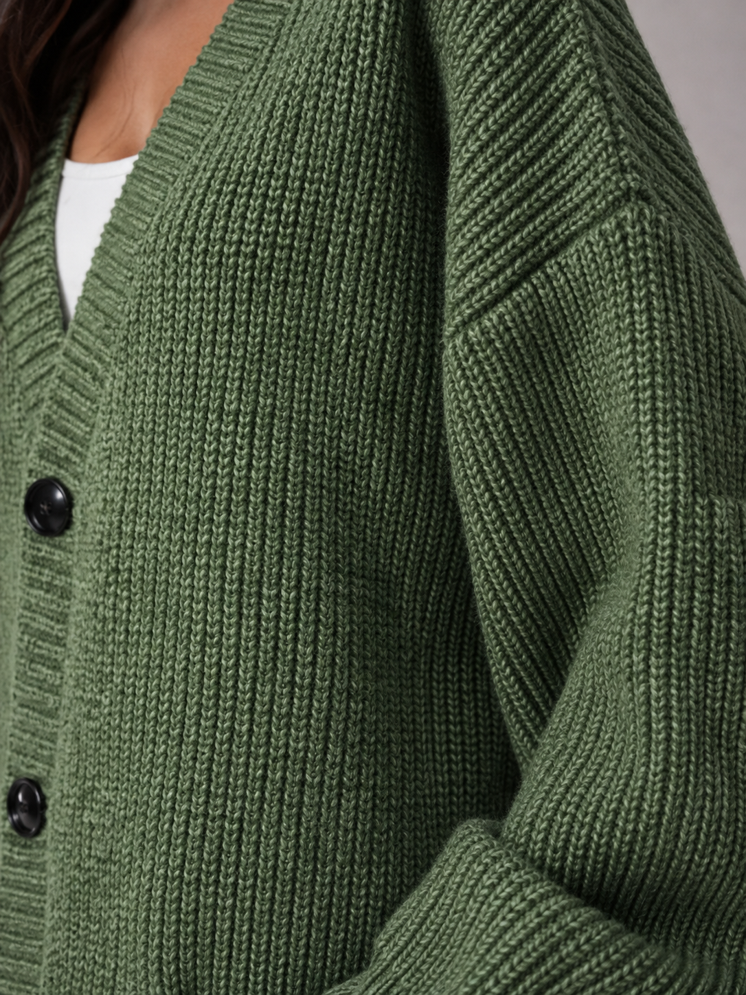 Détail de la maille épaisse et des boutons d'un cardigan oversize pour femme