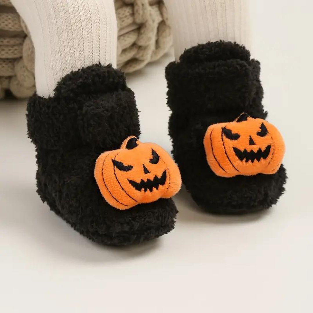 Paire de chaussons d'Halloween noirs à imprimé fantaisie posée sur le sol
