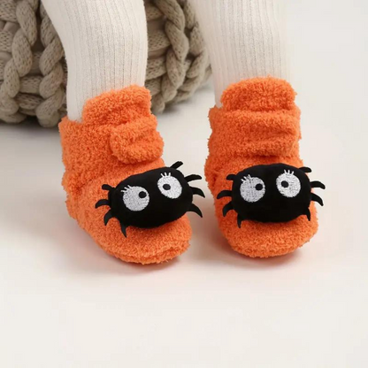 Chaussons d'Halloween orange à imprimé fantaisie portés aux pieds d'un enfant