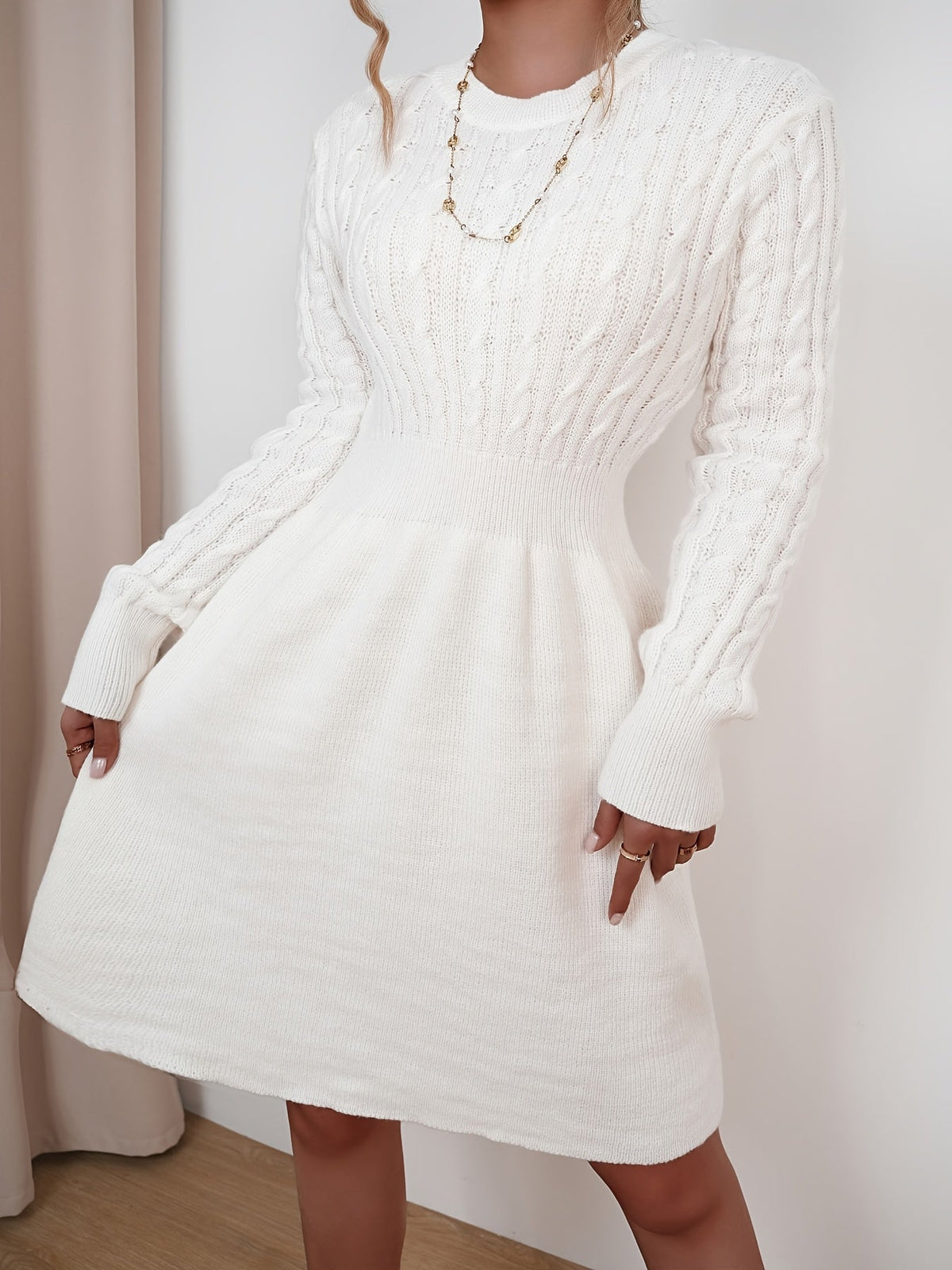 Robe pull torsadée beige portée par une mannequin blonde, vue de face