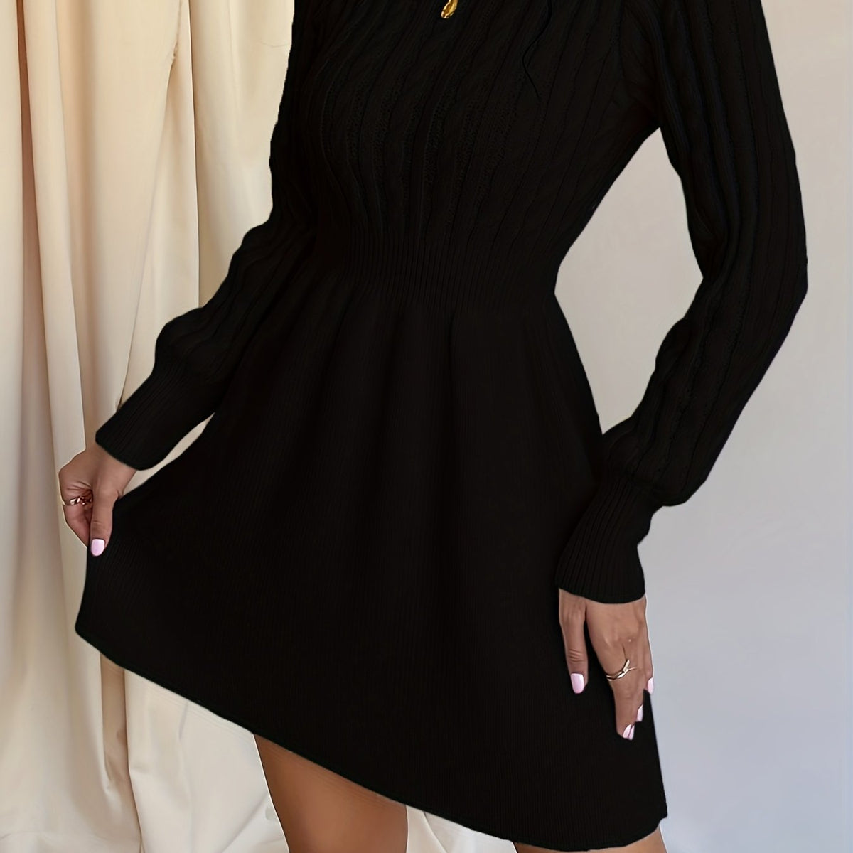 Robe pull torsadée noire, vue latérale rapprochée de la jupe évasée
