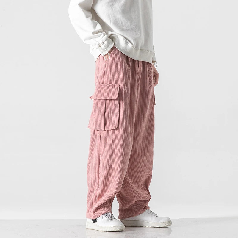 Pantalon de survêtement cargo en velours côtelé rose, vue de profil avec poche cargo plaquée