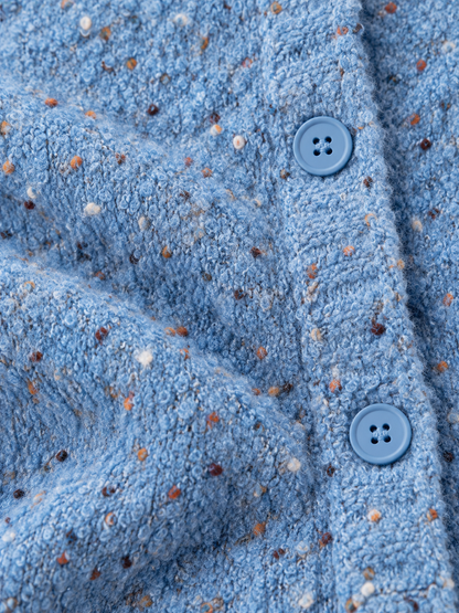 Zoom sur la texture de la maille mouchetée en laine aux détails colorés
