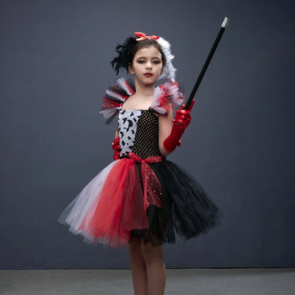 Fille posant en costume de vilaine à pois avec headband à plumes noir et blanc et canne accessoire