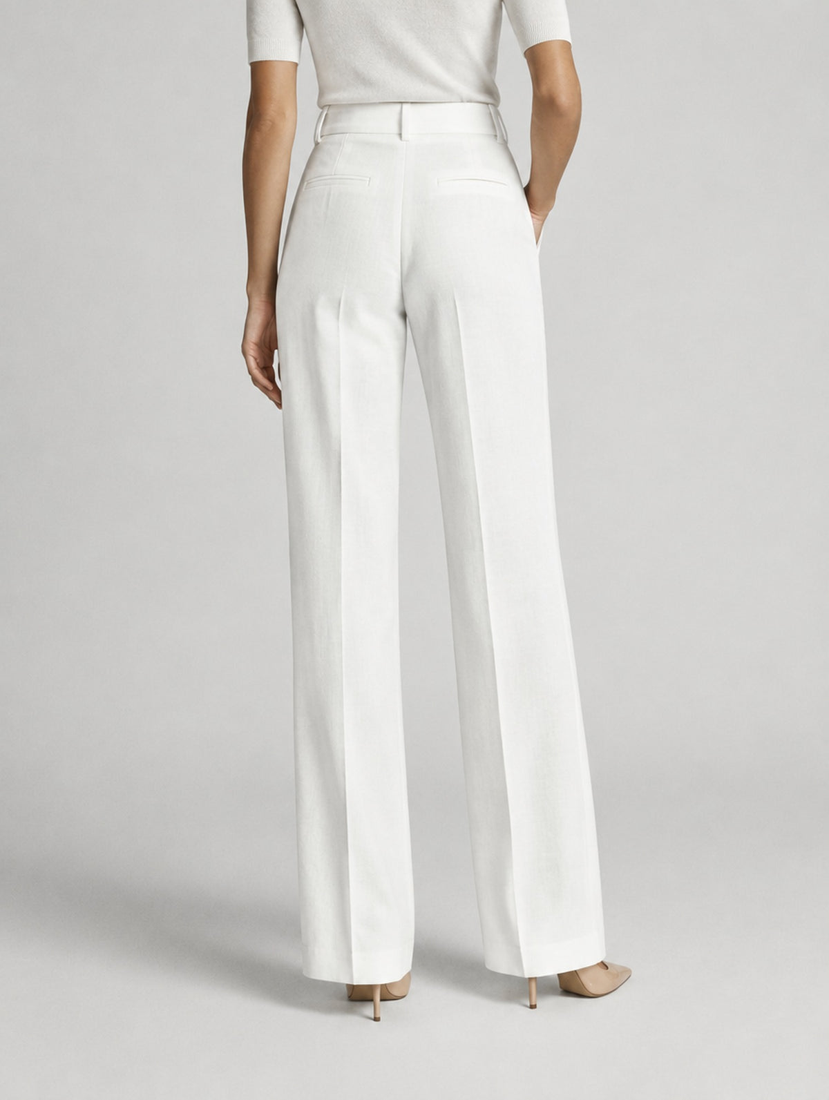 Pantalon large taille haute à plis pour femme, coloris beige, porté par une femme, vue de dos
