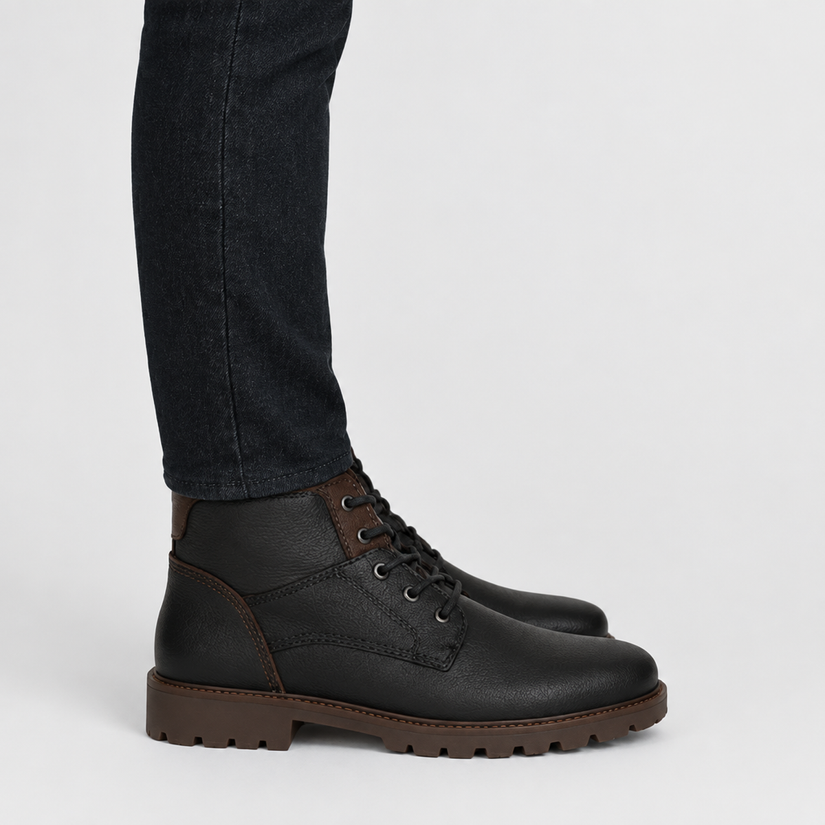 Bottines homme noires à lacets avec empiècements marron, vue de profil portées avec un jean