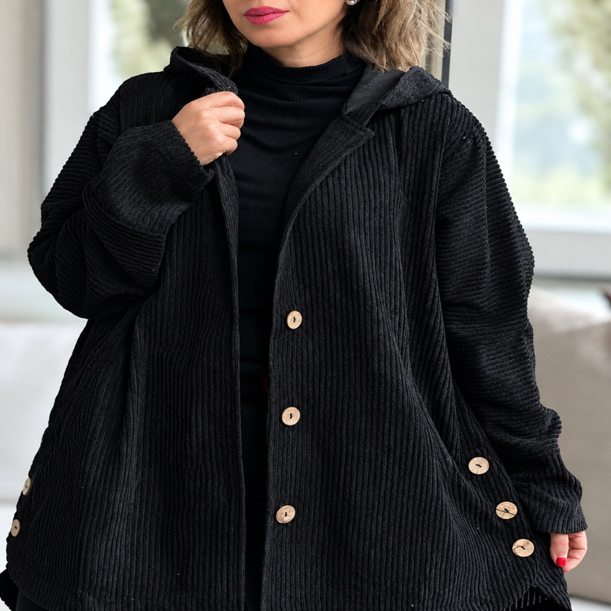 Manteau femme noir à capuche et boutons, vue devant portée par une mannequin