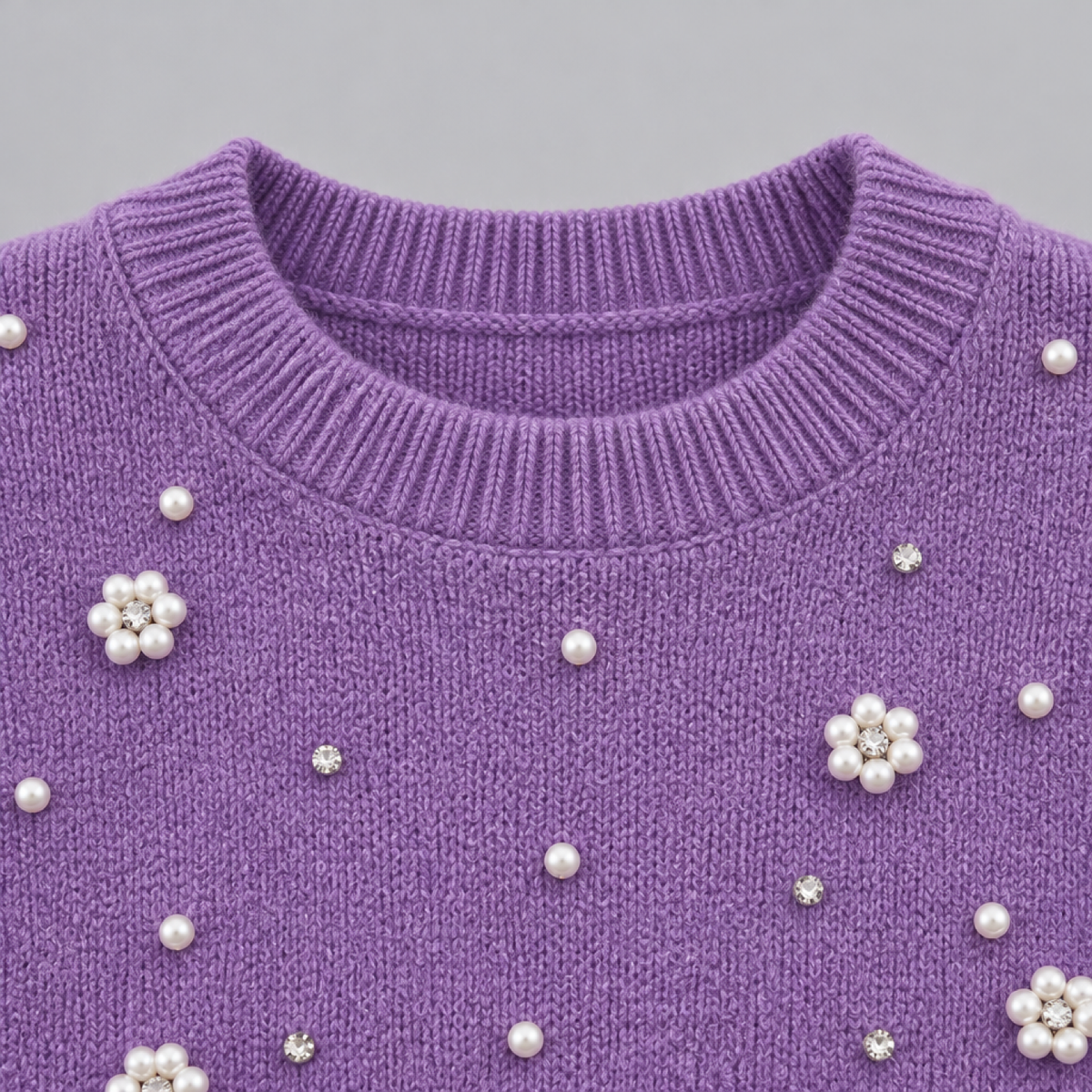 Détail du col rond et de la finition perlée du pull court, coloris violet