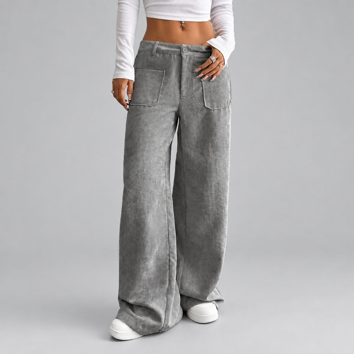 Gros plan sur la texture côtelée du pantalon coloris gris, fond studio neutre