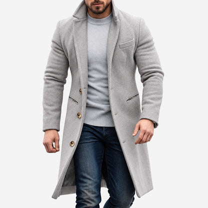 Manteau long homme gris clair à boutons dorés porté avec un jean, vue de face