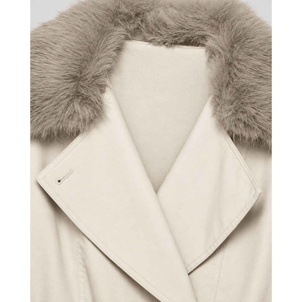 Détail du boutonnage croisé et de la ceinture du trench-coat crème