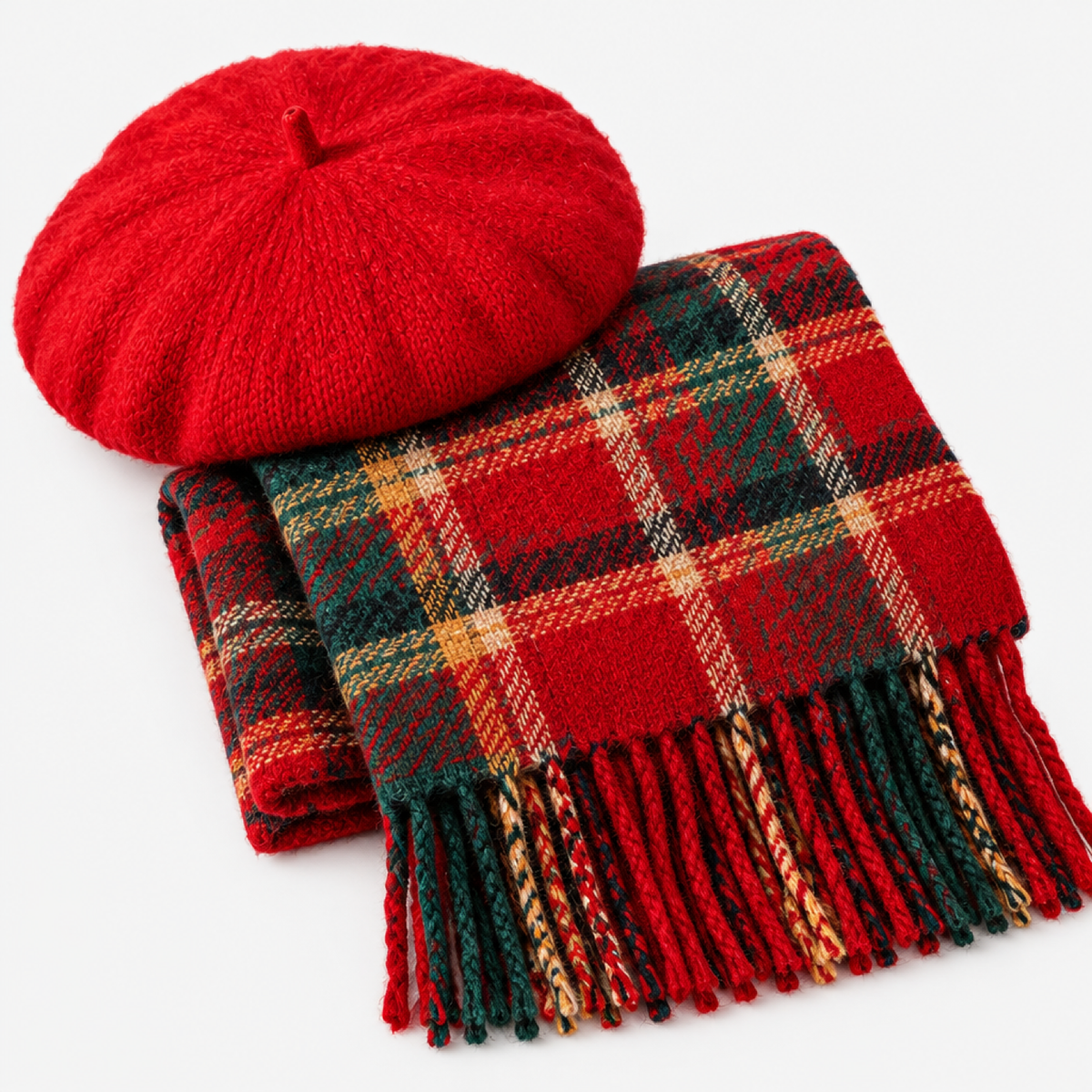 Détail béret en laine rouge et écharpe à carreaux tartan avec franges, fond studio clair