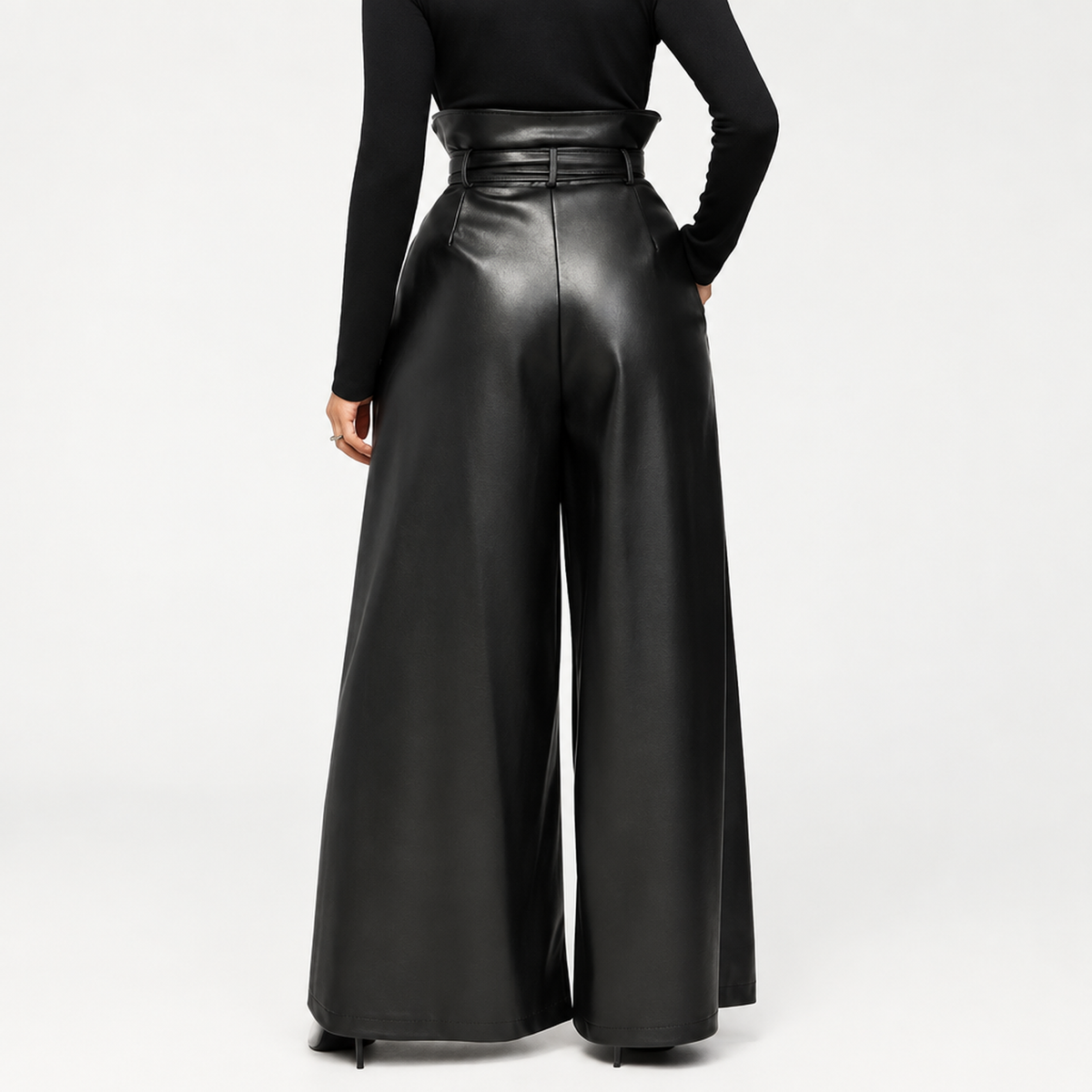 Pantalon femme taille haute ceinturé en simili cuir, porté avec un chemisier blanc, vue de face