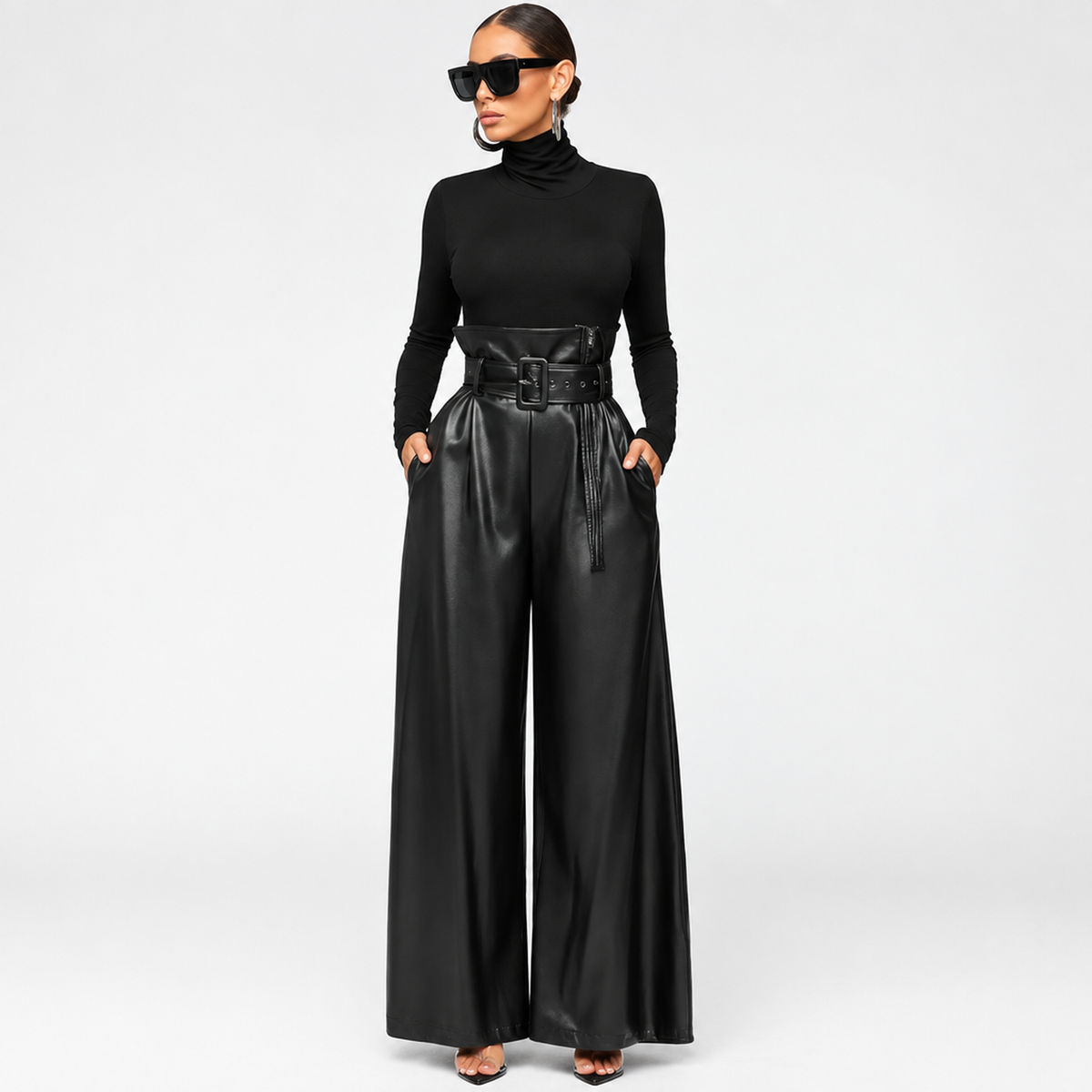 Pantalon femme taille haute ceinturé en simili cuir noir, porté avec un col roulé, vue de face