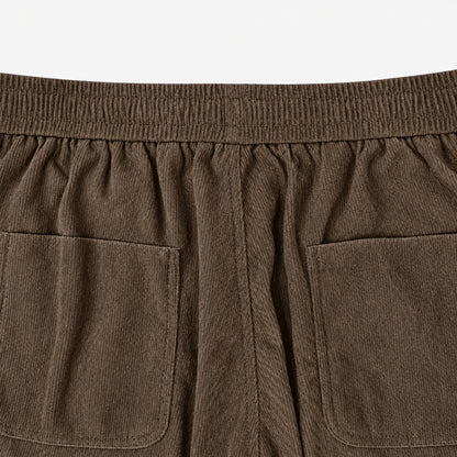 Gros plan sur la taille élastique et les poches arrière du pantalon en velours côtelé marron