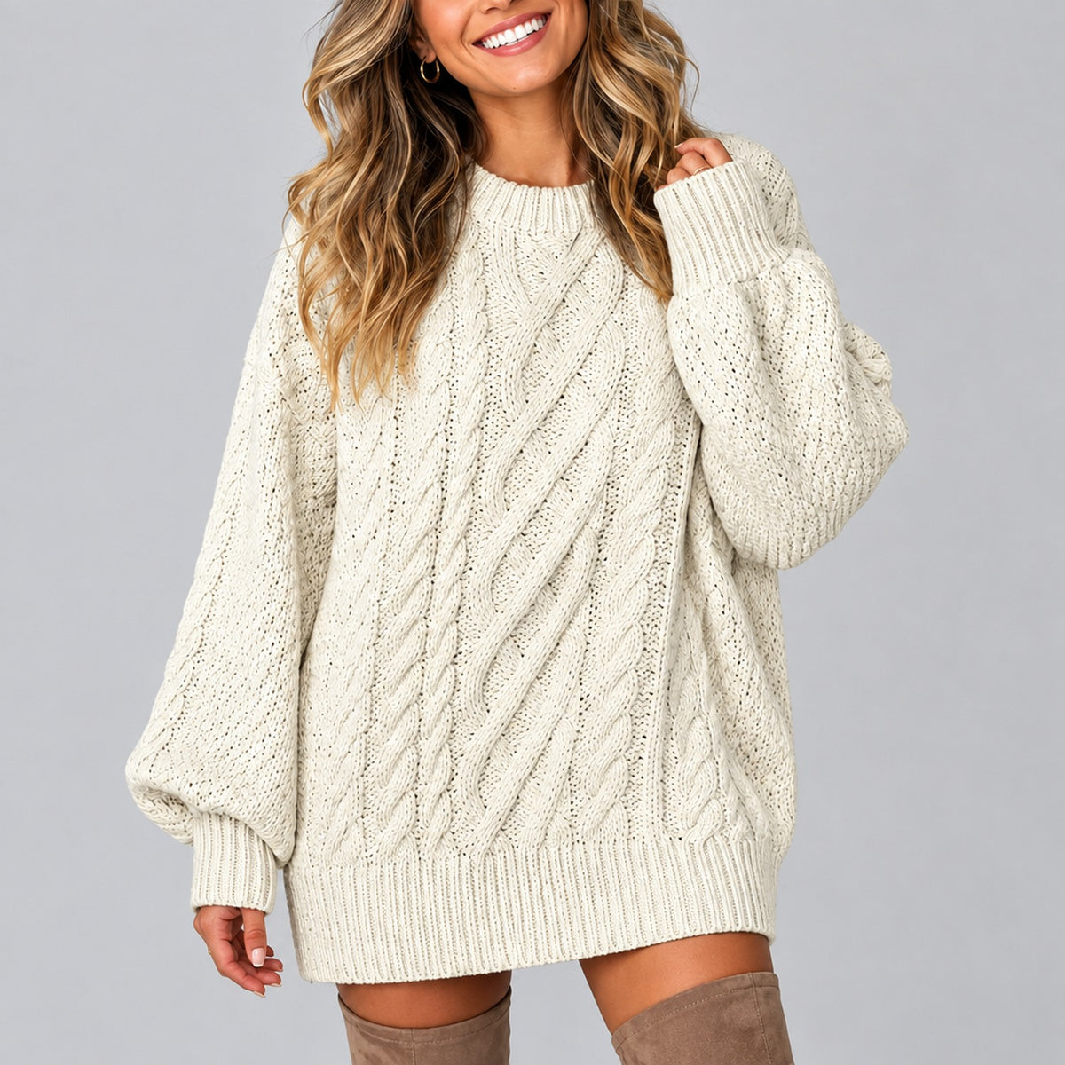 Pull oversize femme beige à torsades, coupe effet robe portée avec bottes hautes