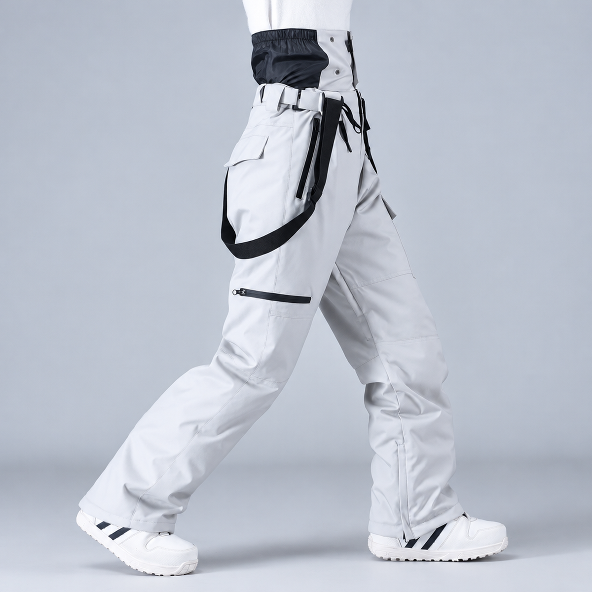 Pantalon de snowboard unisexe gris, vue de profil montrant les bretelles et les poches cargo
